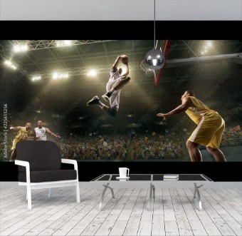 Picture of Basketball players on big professional arena during the game Basketball player makes slum dunk